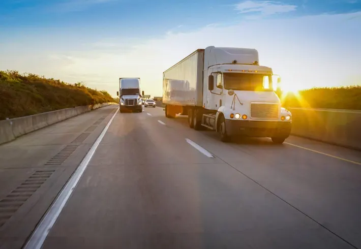 Trucks on a regional highway at sunset
